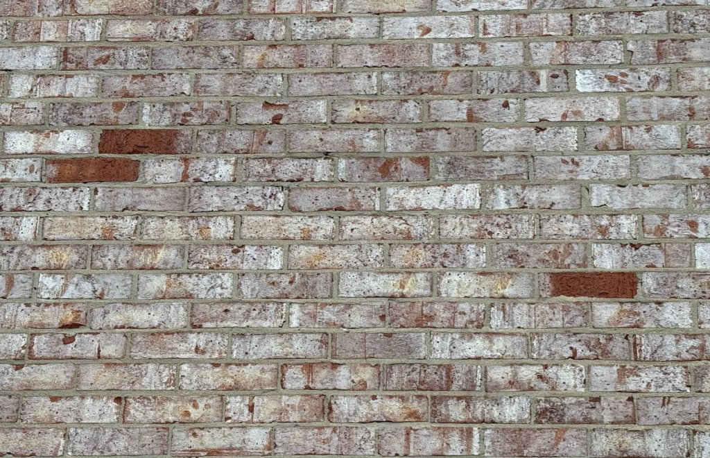     Close-up of brick exterior wall with varied tones and texture