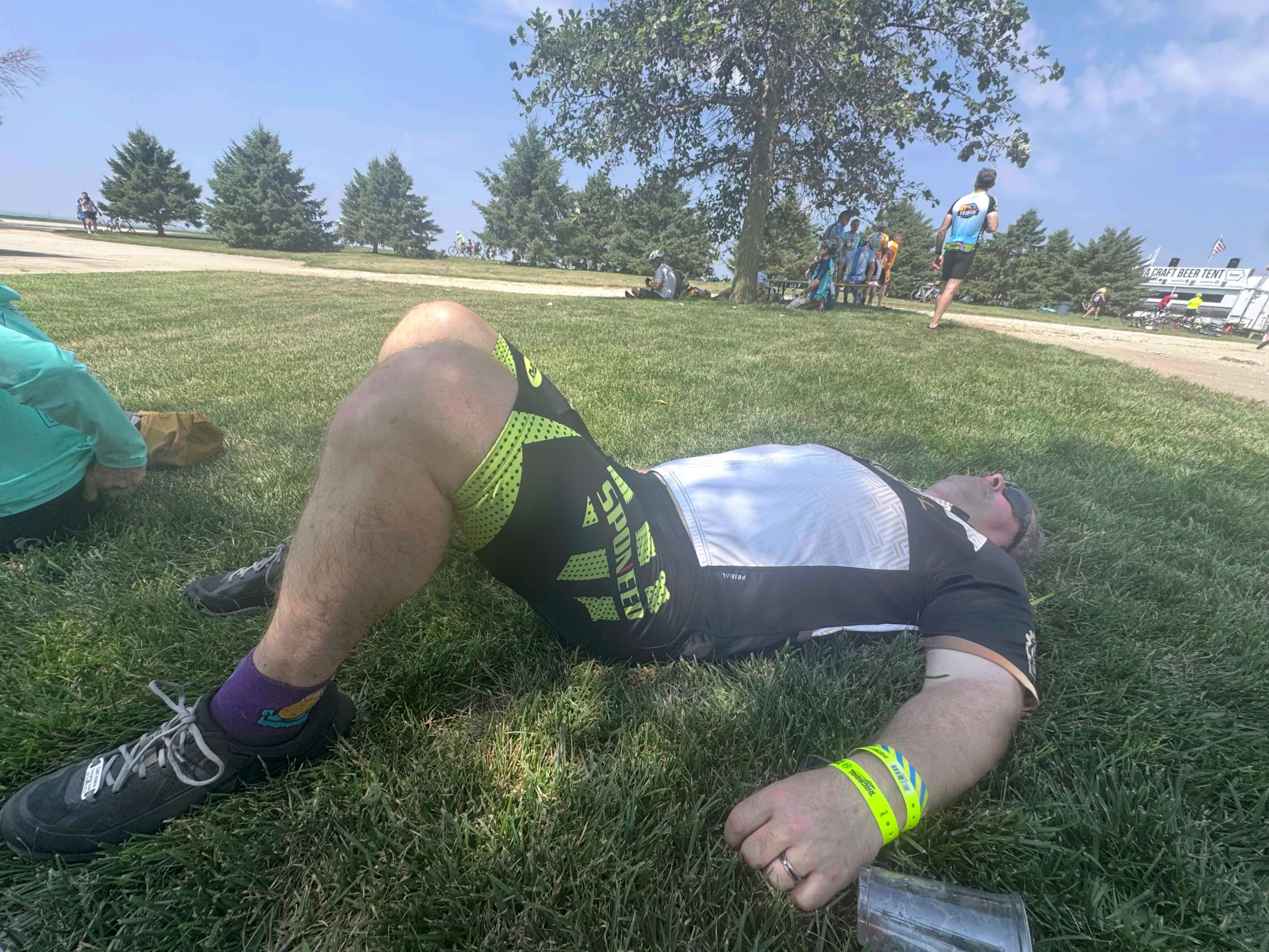 RAGBRAI rider resting on the grass during the ride across Iowa