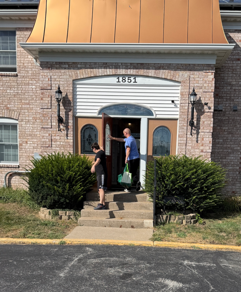 Resident returning home with groceries at Cambridge Place Apartments in Iowa City, demonstrating everyday apartment living habits.